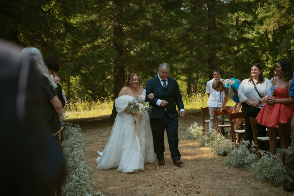 bride walking down the aisle looking at the groom and guests