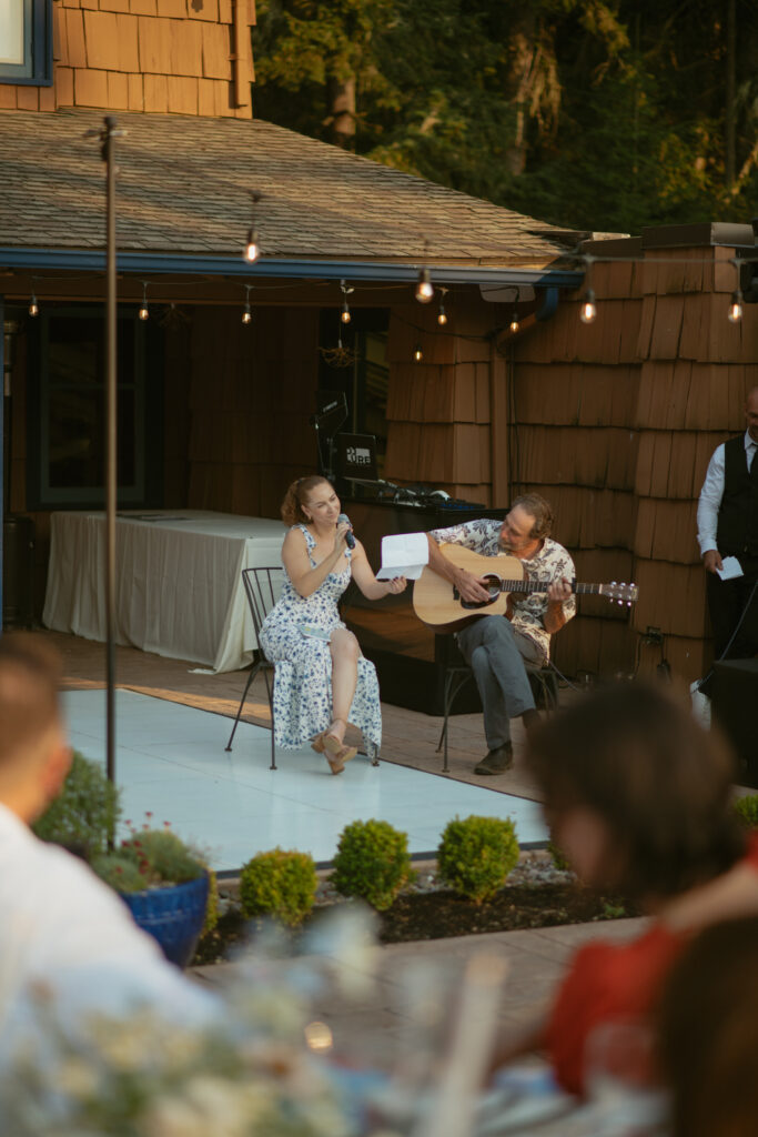 MOH singing to couple and crying captured during reception coverage by hybrid photo and video team.