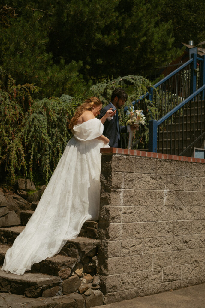 Bride and groom holding hands and walking together outdoors after their wedding ceremony, captured in a natural, candid moment.