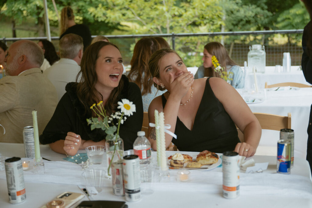 couple laughing during dinner talking to guests 