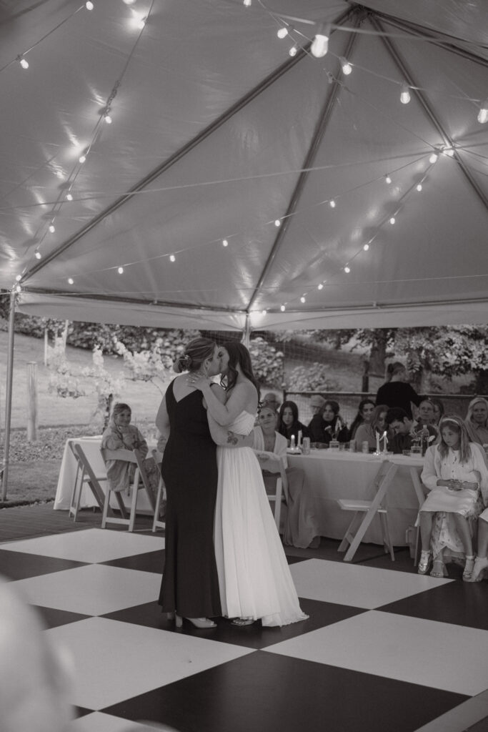 the couples first dance as a married couple on a checkered dance floor and lights on a pnw backyard wedding day