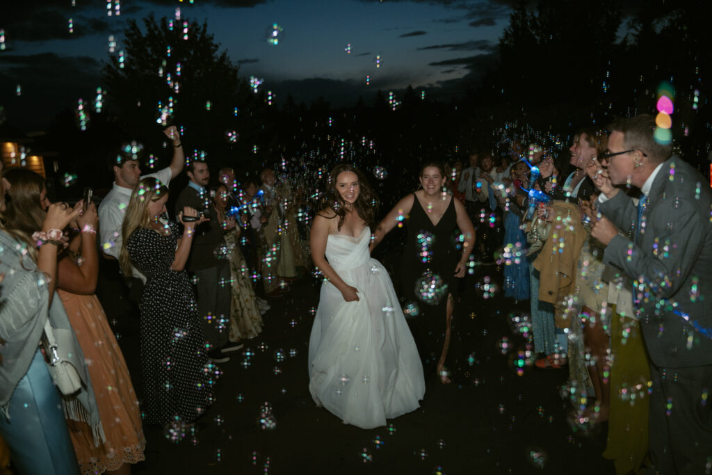 couple running in bubbles for there send off from the their backyard wedding in the PNW