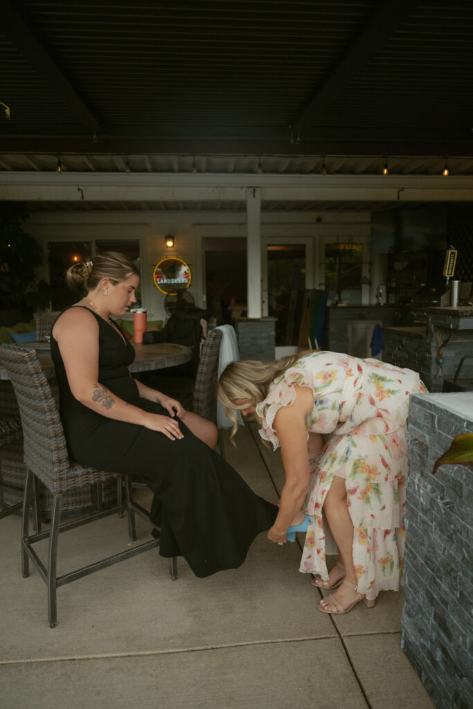Bride getting ready at the outdoor backyard wedding venue with friends before the ceremony.