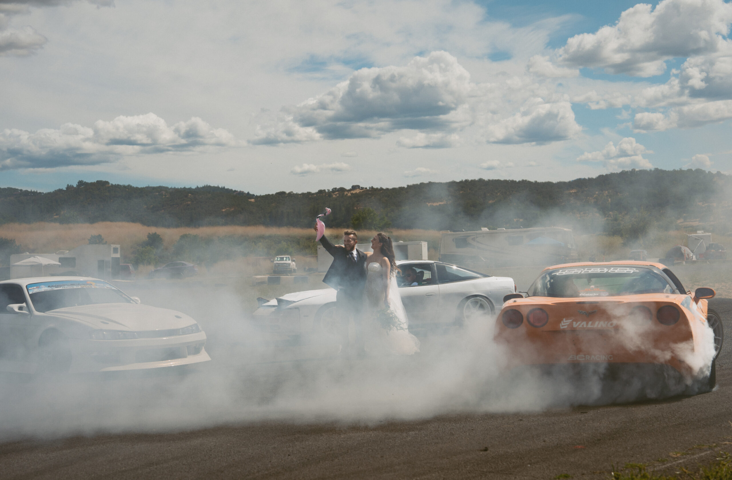 A couple with cars racing around them on there way day